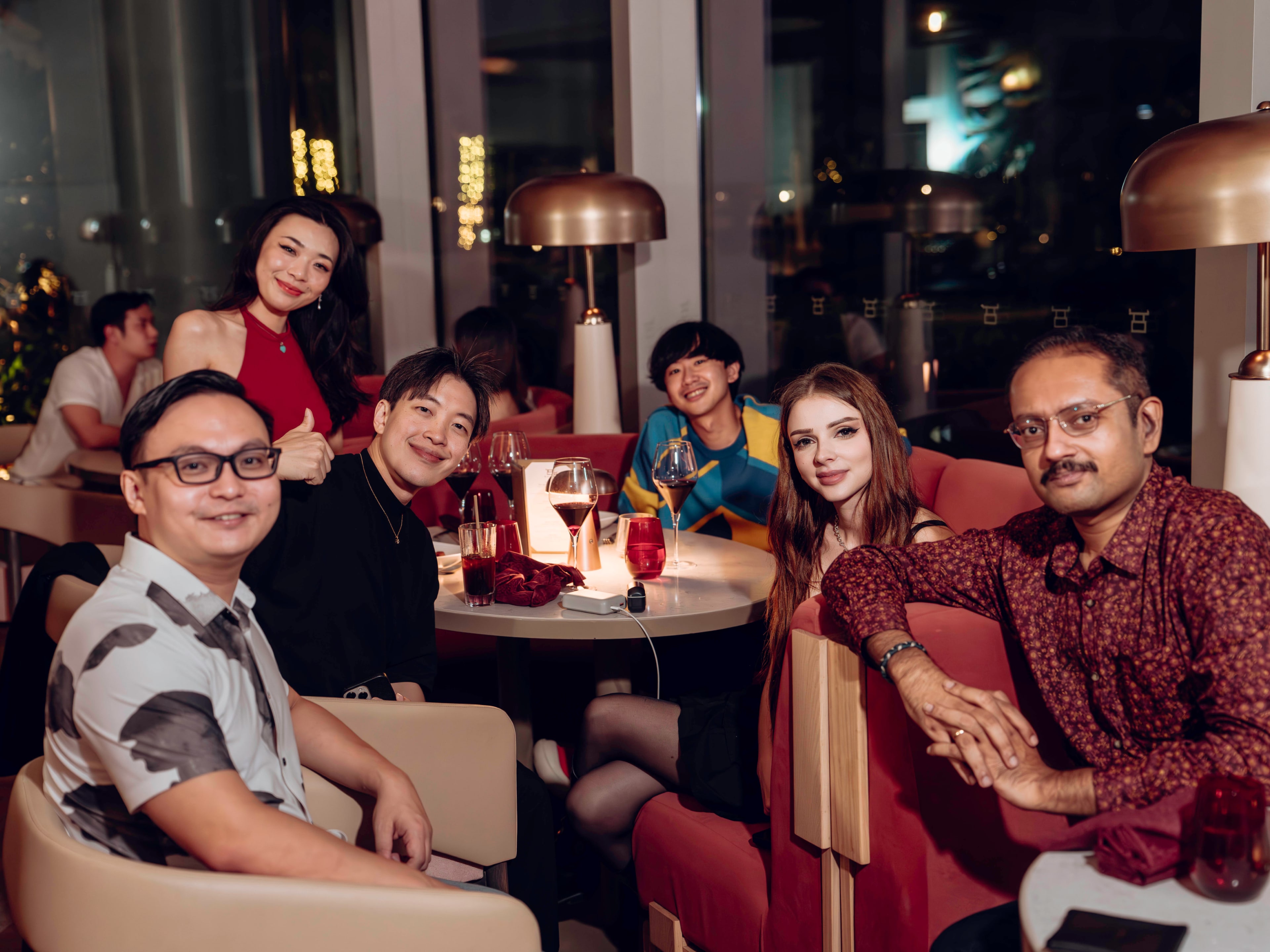 Guests seated together around a table at an evening gathering.