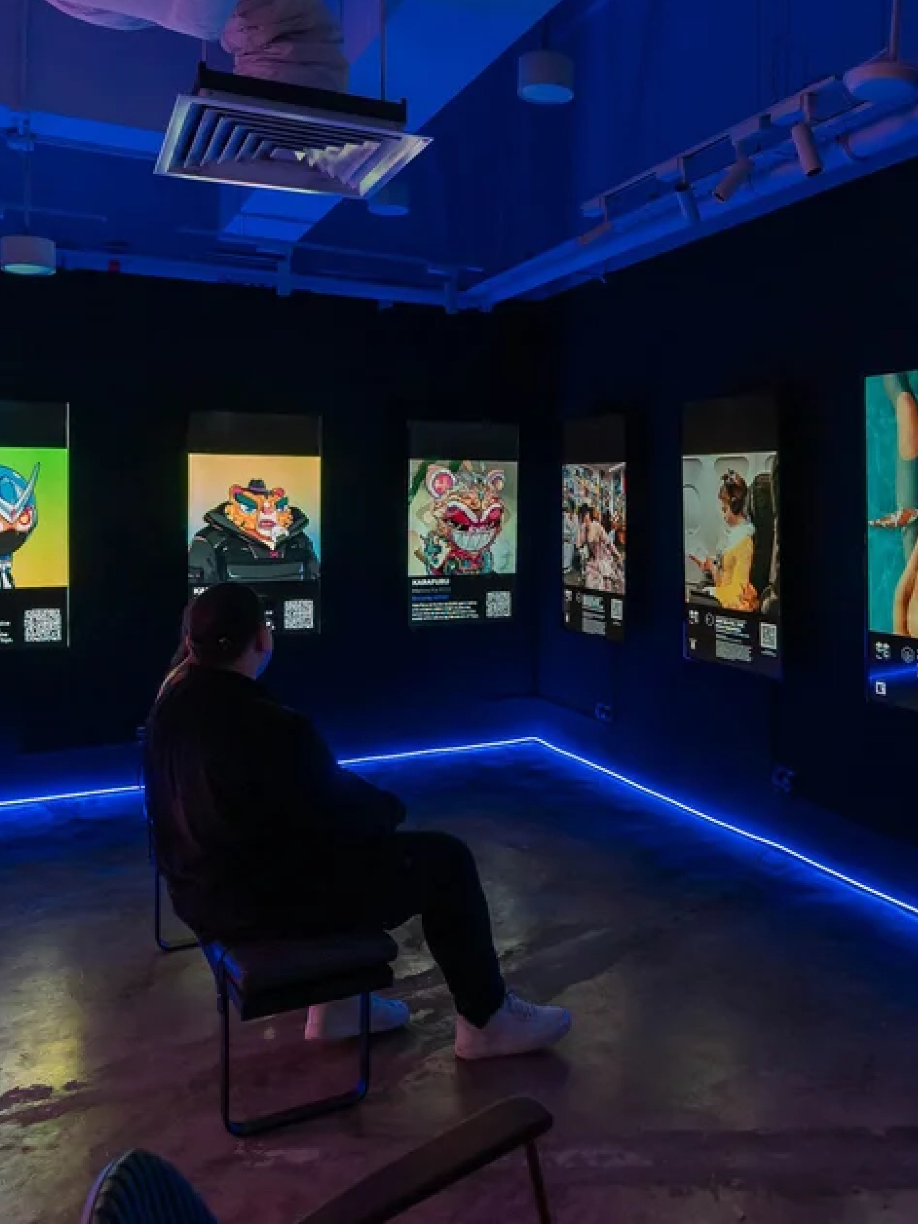 A visitor seated inside an immersive digital exhibition.