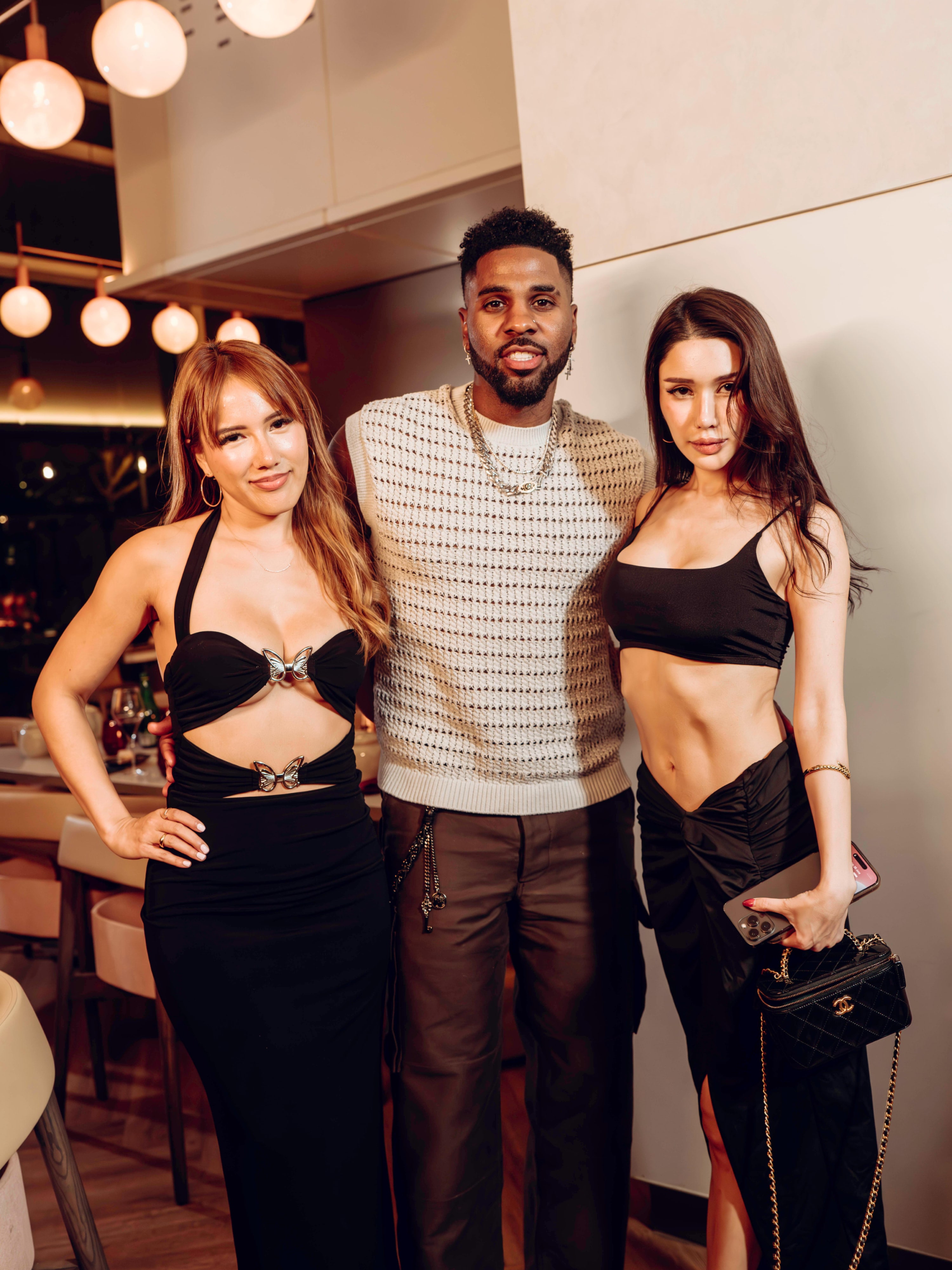 Three guests posing together at a private evening event.