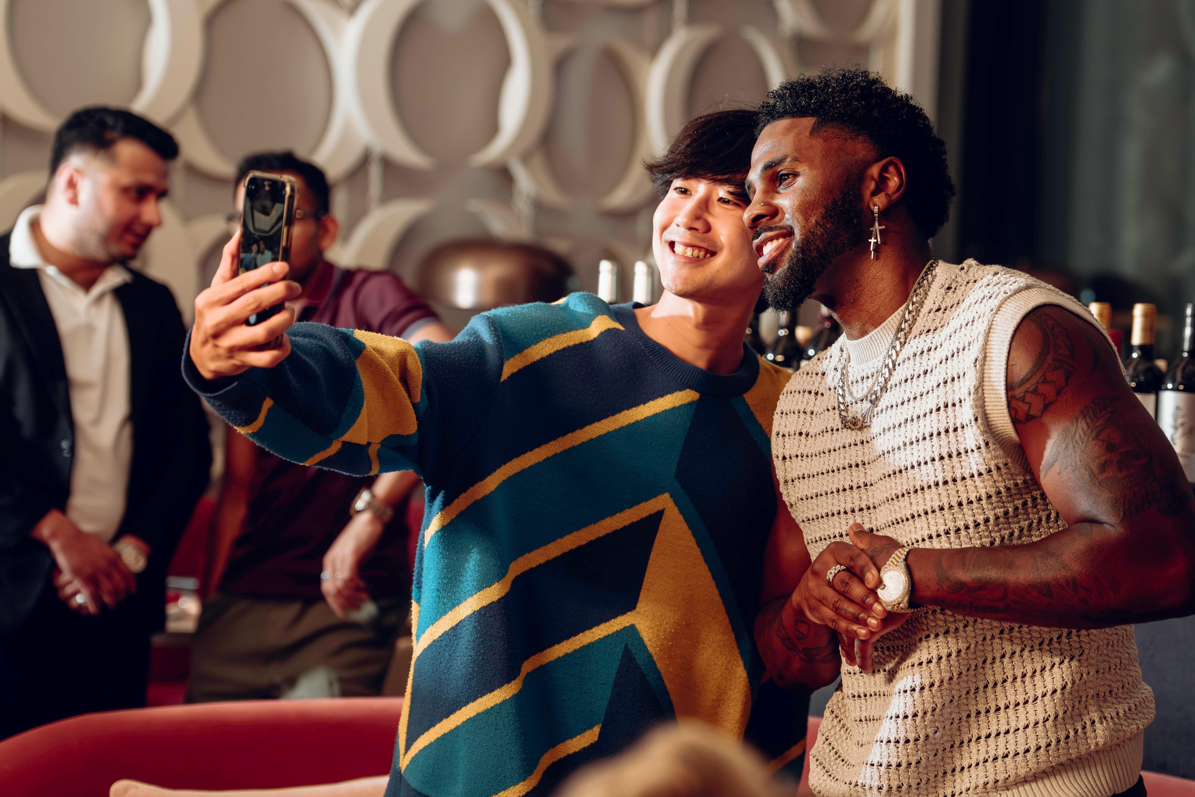 Two guests posing for a phone photo at an APEX AURA gathering.